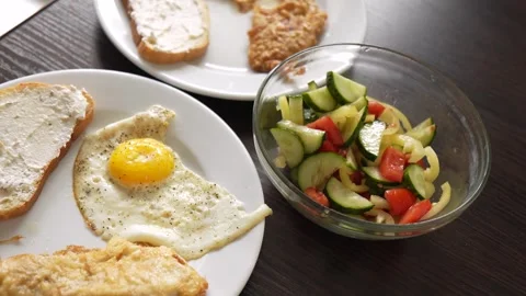 Breakfast fried eggs with salad and toast. Two servings Stock Footage 283449672