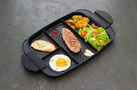 Breakfast, fried steak or cutlet, salad with tomato and green vegetables, toa Fotos Stock