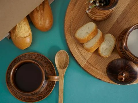 Breakfast in handmade earthenware top view. Cup of tea, milk in a jug, baguette Fotos Stock