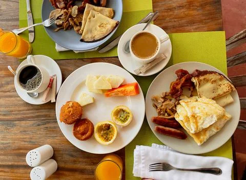 Breakfast in the hotel restaurant on the table with scrambled eggs, bacon, pa Stock Photos
