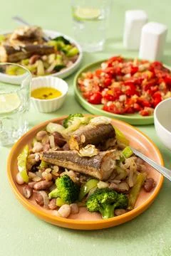 Breakfast includes baked hake placed on a bed of boiled beans with broccoli.. Stock Photos