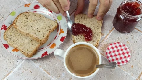 Breakfast, with jam spread on a slice of bread. 스톡 동영상 274290207