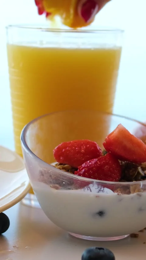 Breakfast juice berries orange grapefruit juice from juicer into glass on Stock Footage 317701124