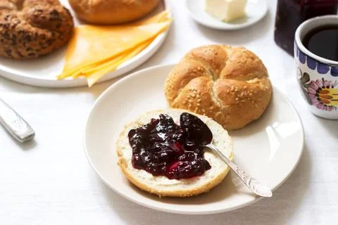 Breakfast with Kaiser rolls, currant jam, butter and cheese and tea. Stock Photos