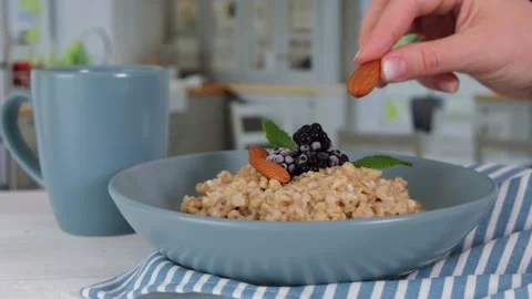 Breakfast in the kitchen, oatmeal with berries and walnut. Stock Footage 154298166