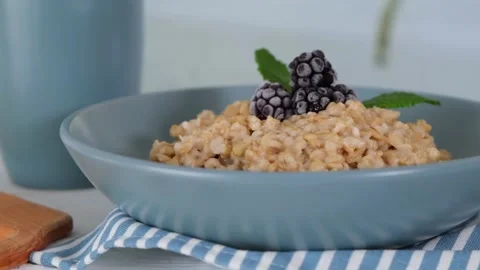 Breakfast in the kitchen, oatmeal with berries and walnut. Healthy food concept Stock Footage 154631804