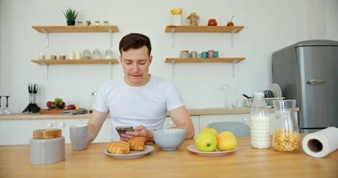 Breakfast in the kitchen with the phone in hand. Stock Footage 279405786