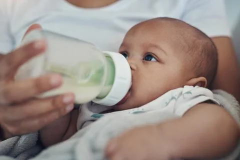 Breakfast, lunch and dinner all in a bottle. an adorable baby girl being bottle Stock Photos