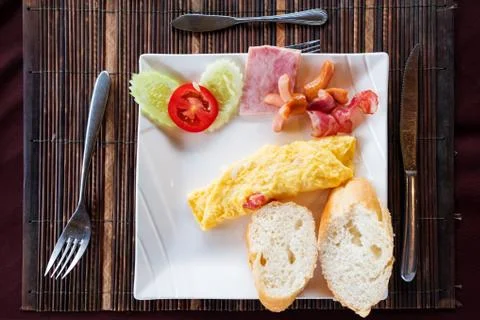 Breakfast meal, omelet egg with breads and vegetable side dishes on the table Stock Photos