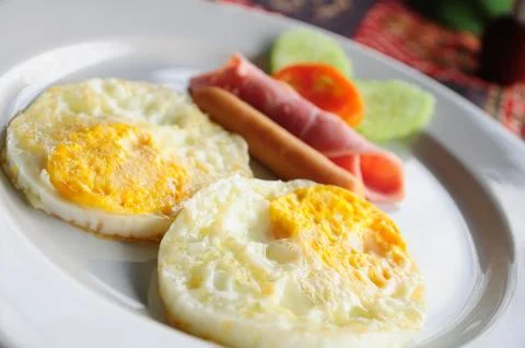 Breakfast meal, two eggs, ham and vegetables. Stock Photos