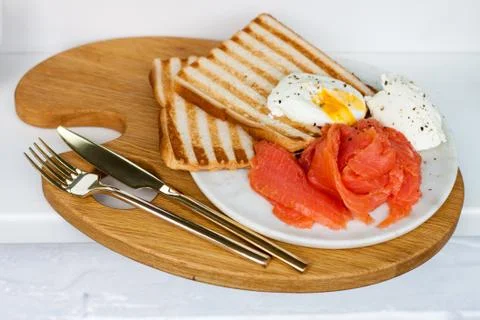 Breakfast menu: toasted bread, smoked salmon, poached eggs and cup of coffee Stock Photos
