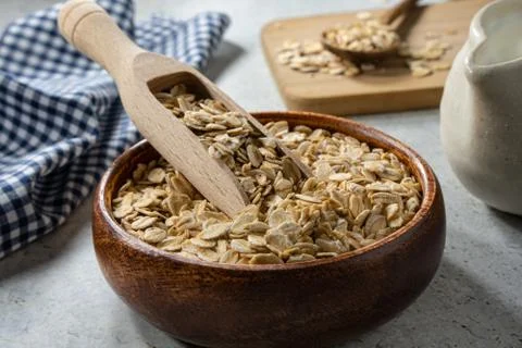 Breakfast oats inside rustic bowl with wooden scoop.  Stock Photos