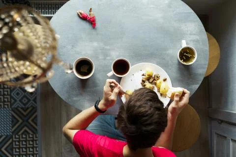 Breakfast at the oval table by the window. Stock Photos