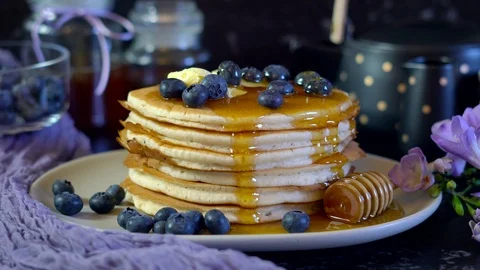 Breakfast pancake stack served with blueberries and honey. 스톡 동영상 115242398