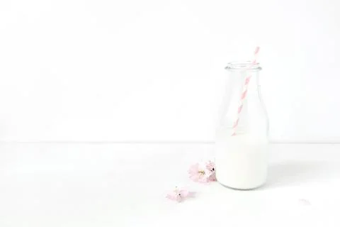 Breakfast party desktop scene. Composition with milk glass jar, pink drinking Foto stock
