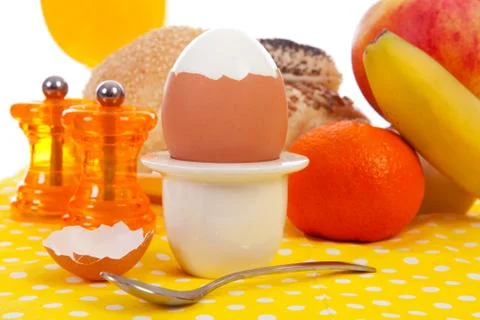 Breakfast with peeled egg, delicious bread and fruits Stock Photos