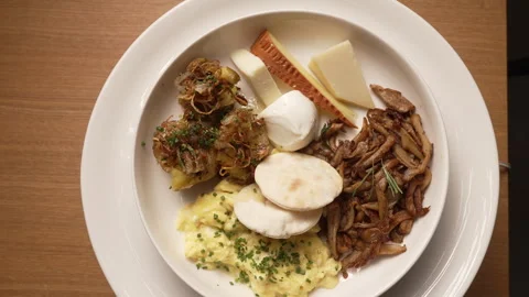 Breakfast plate featuring scrambled eggs, cheese, fresh vegetables, olives Video stock 335393012