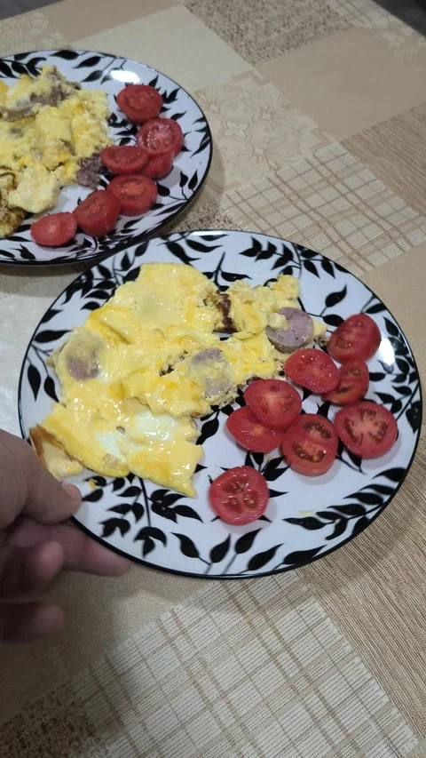 Breakfast plate with fluffy scrambled eggs, sausage slices, and fresh tomat.. Stock Footage 318586068