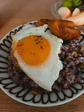 Breakfast Plate with Fried Egg Black Rice and Sausages Stock Photos