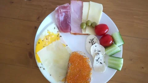 Breakfast Plate with fried egg, cheese slices, olives, cherry tomatoes, cucumber Stock Footage 297613338