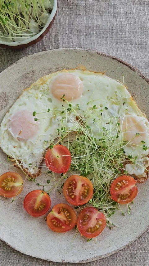 Breakfast Plate With Fried Eggs, Cherry Tomatoes and Microgreens Video stock 324586684
