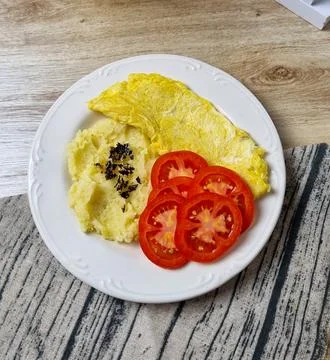 Breakfast Plate: Omelette, Mashed Potatoes, and Tomato Slices 库存照片