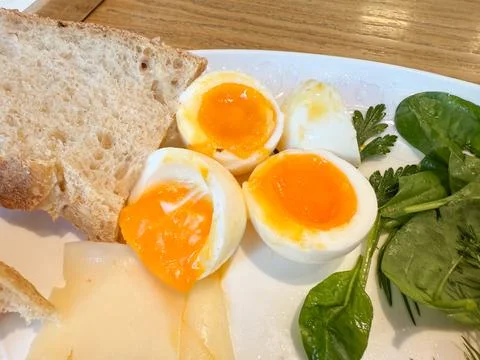 Breakfast plate with soft-boiled eggs, bread and greens. Healthy meal, mornin 写真素材