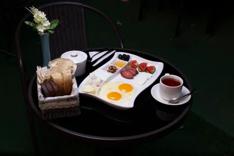 Breakfast platter with fried eggs on black table served with sausages Stock Photos