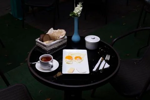 Breakfast platter with fried eggs, a cup of tea and bread Stock Photos