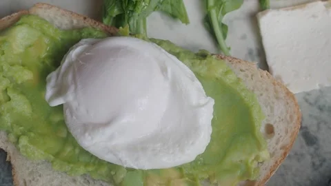 Breakfast with poached egg and avocado on toast Stock Footage 335913469