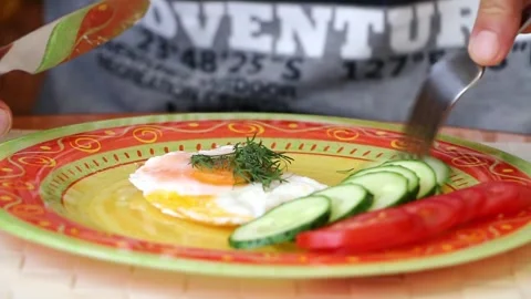 Breakfast preparation with fried egg and fresh vegetables Stock-Footage 320198776