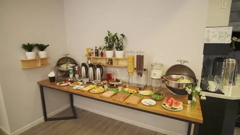Breakfast room in a small hotel. Served table with sausages, meat, salads Stock Footage 307743568