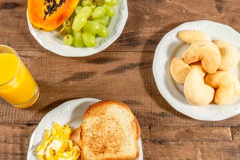 Breakfast, on a rustic table, white plate with toast and eggs, with orange ju Stock Photos