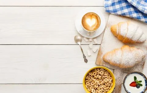 Breakfast scene with eggs bread cereal and milk on white table Stock Photos
