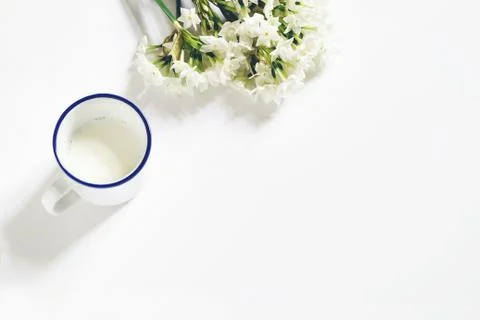 Breakfast scene. Spring composition with mug of milk and bouquet of narcissus Photos