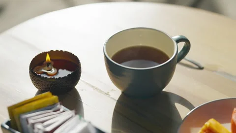 Breakfast scene with tea cup and plate of food on a wooden table outdoors Video stock 328043161