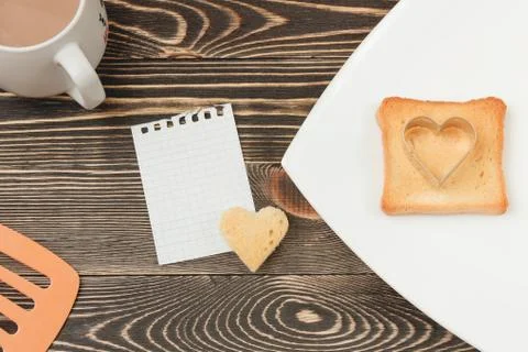 Breakfast scene with toast, cup on wooden table. Stock Photos