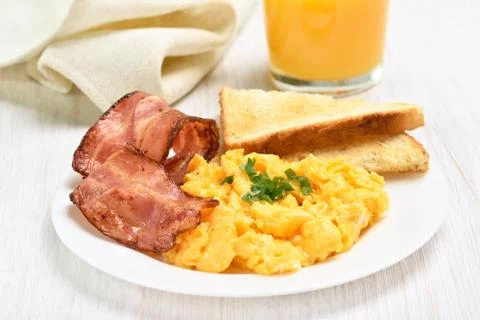 Breakfast with scrambled eggs and bacon Stock Photos