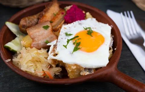 Breakfast of scrambled eggs with fried bacon and potatoes Stock Photos
