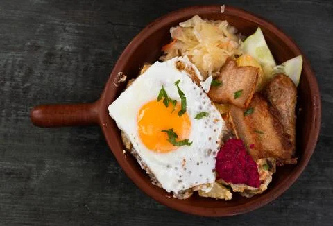Breakfast of scrambled eggs with fried bacon and potatoes Stock Photos