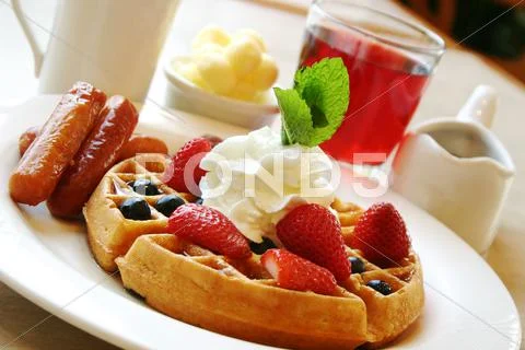 Breakfast series - blueberry waffles with strawberries and sausages Stock Photos