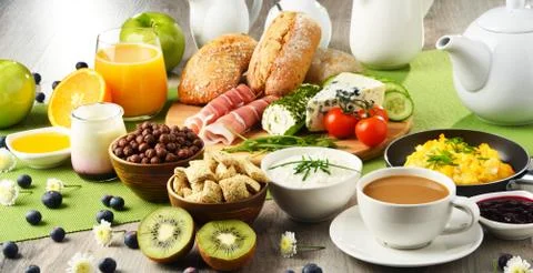 Breakfast served with coffee, orange juice, cheese, cereals and scrambled eggs.  Stock Photos