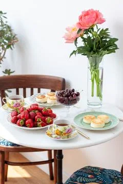 Breakfast served on marble table. Tea, fresh strawberry, cottage cheese panca Stock Photos