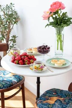 Breakfast served on marble table. Tea, fresh strawberry, cottage cheese panca Stock Photos
