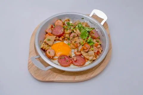 Breakfast set. Pan of fried eggs with bacon, chinese sausage, pork sausage, p Stock Photos