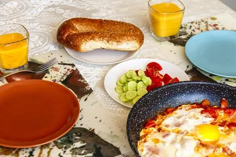 Breakfast set with scrambled eggs, fresh vegetables, fresh bread and orange j Stock Photos