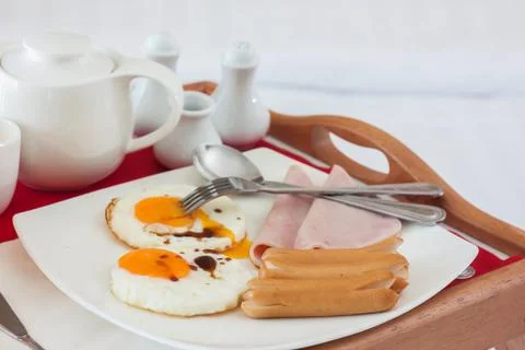 Breakfast set in tray on bed Stock Photos