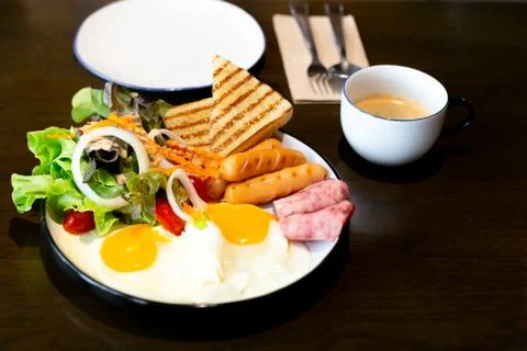 Breakfast set, with vegetable, ham, bacon, fried egg, sausage and cup of coffee. Stock Photos