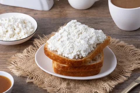Breakfast setup with bread, cottage cheese, coffee, and jam on a wooden Foto stock