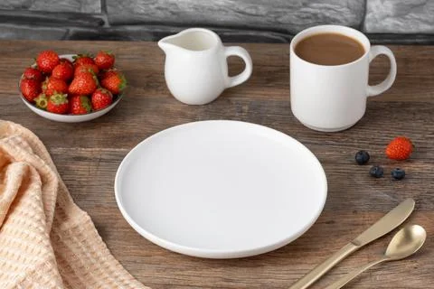 Breakfast Setup with Coffee, Strawberries, and Empty Plate Stock Photos